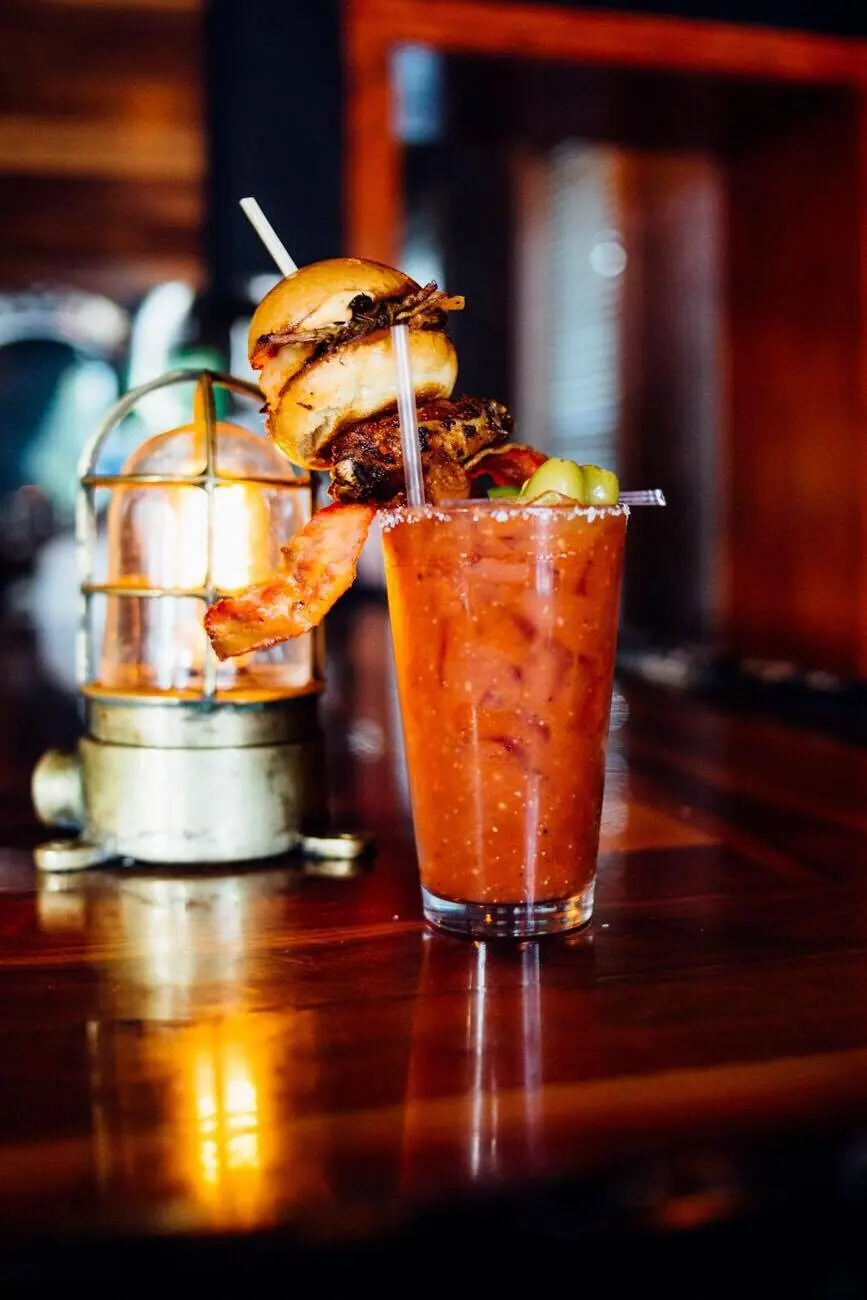 The famous Yacht Club Bloody Mary — slider, smoked wing and bacon skewer at the bar