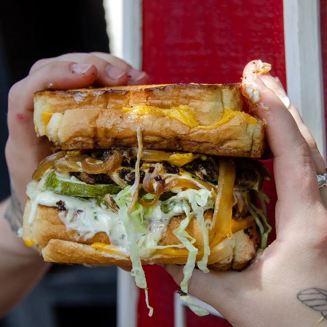 Fucc Boi Vegan — Beyond burger with shredded lettuce, housemade tartar, USA cheese, pickles and onions between two grilled cheeses