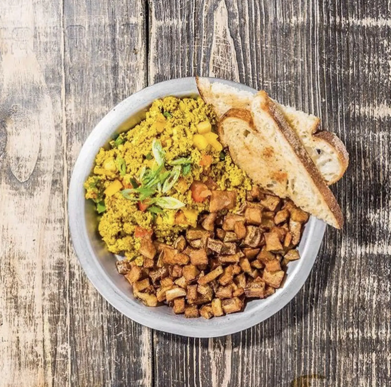 Killer Tofu — turmeric-cumin tofu scramble with peppers and onions, smashed red potatoes, and sourdough toast