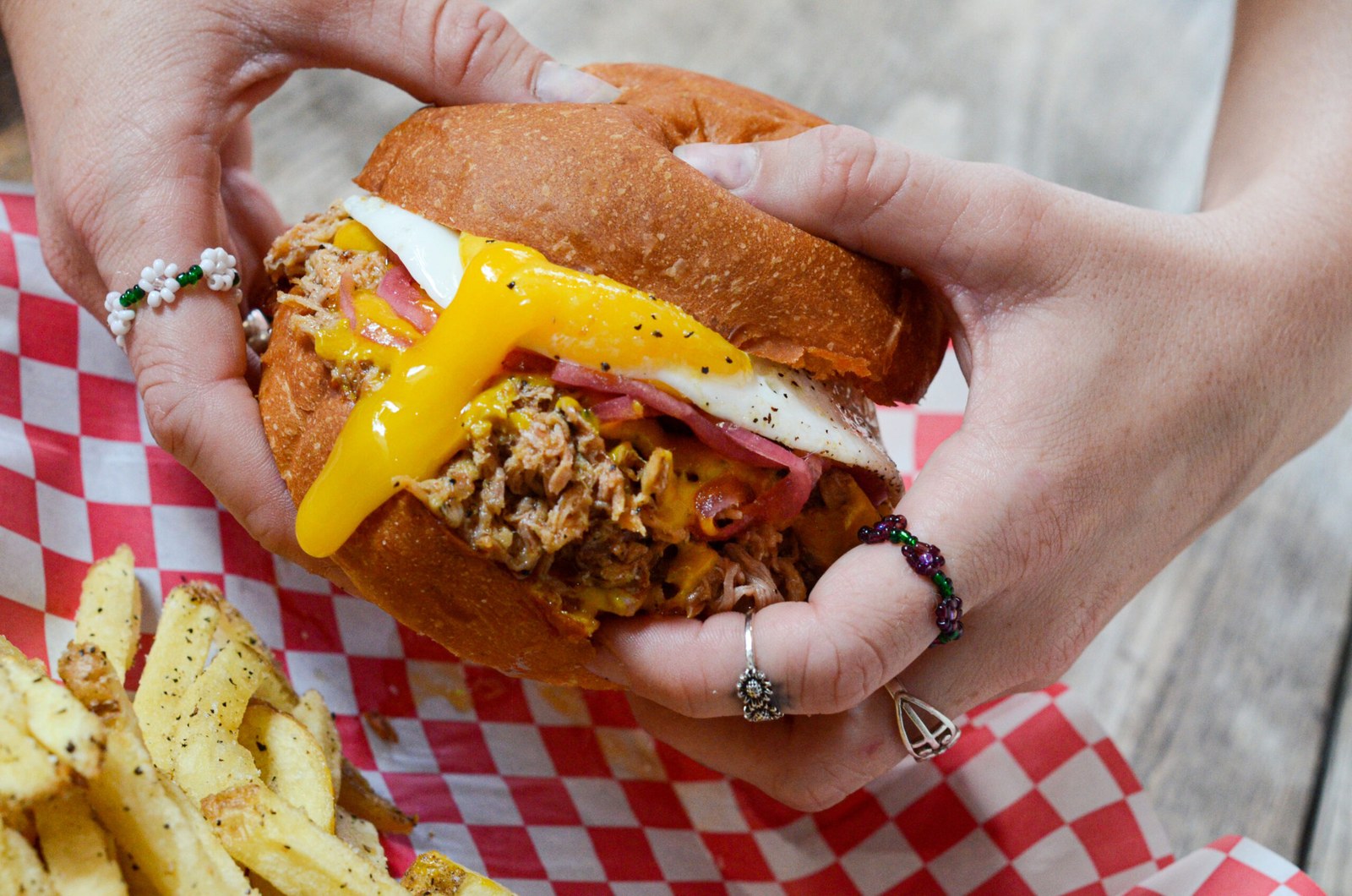 Smoked Pulled Pork Sandwich with fried egg, pickled red onions, and Carolina mustard BBQ