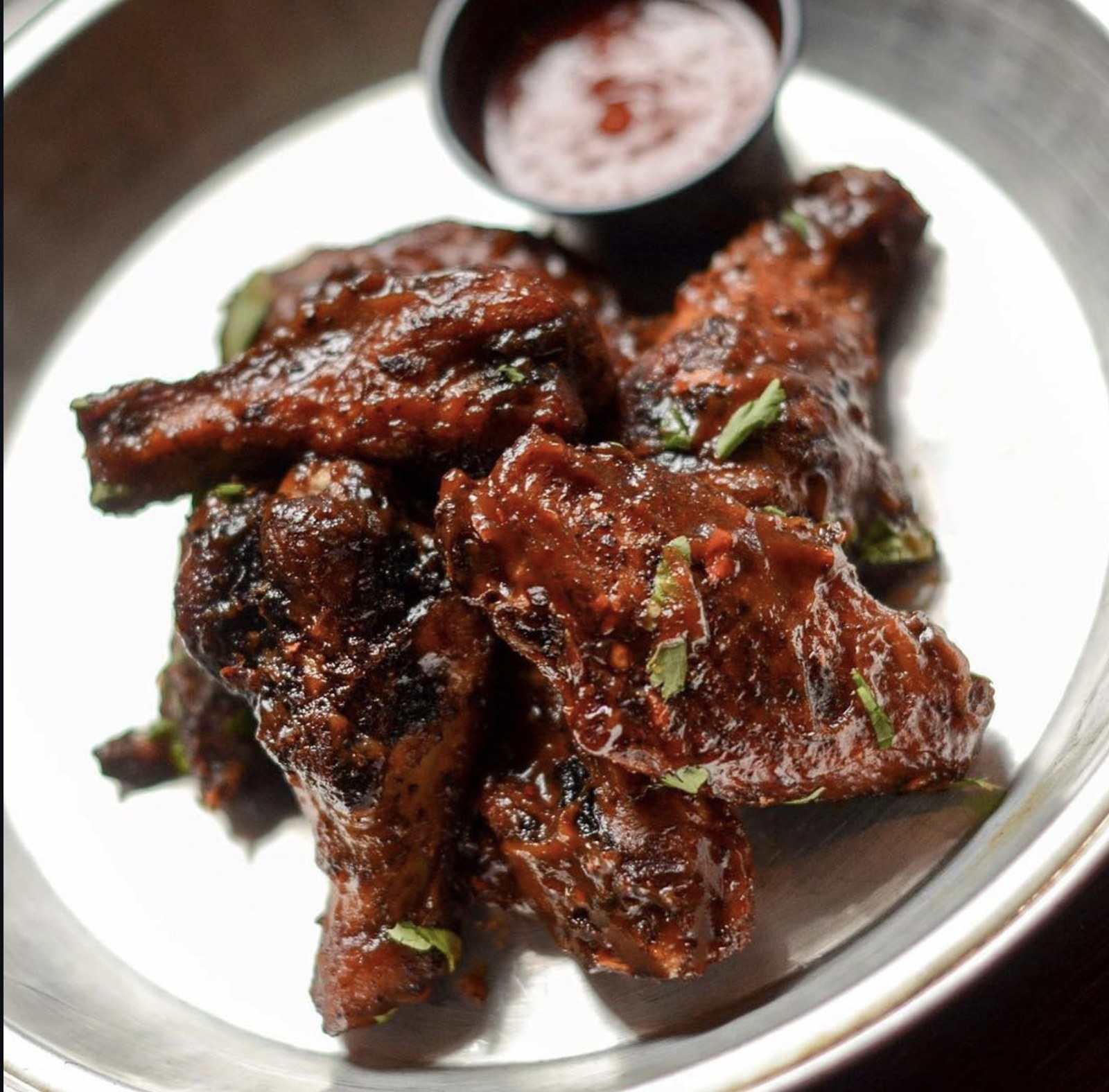House Smoked Wings glazed in BBQ sauce with cilantro and dipping sauce